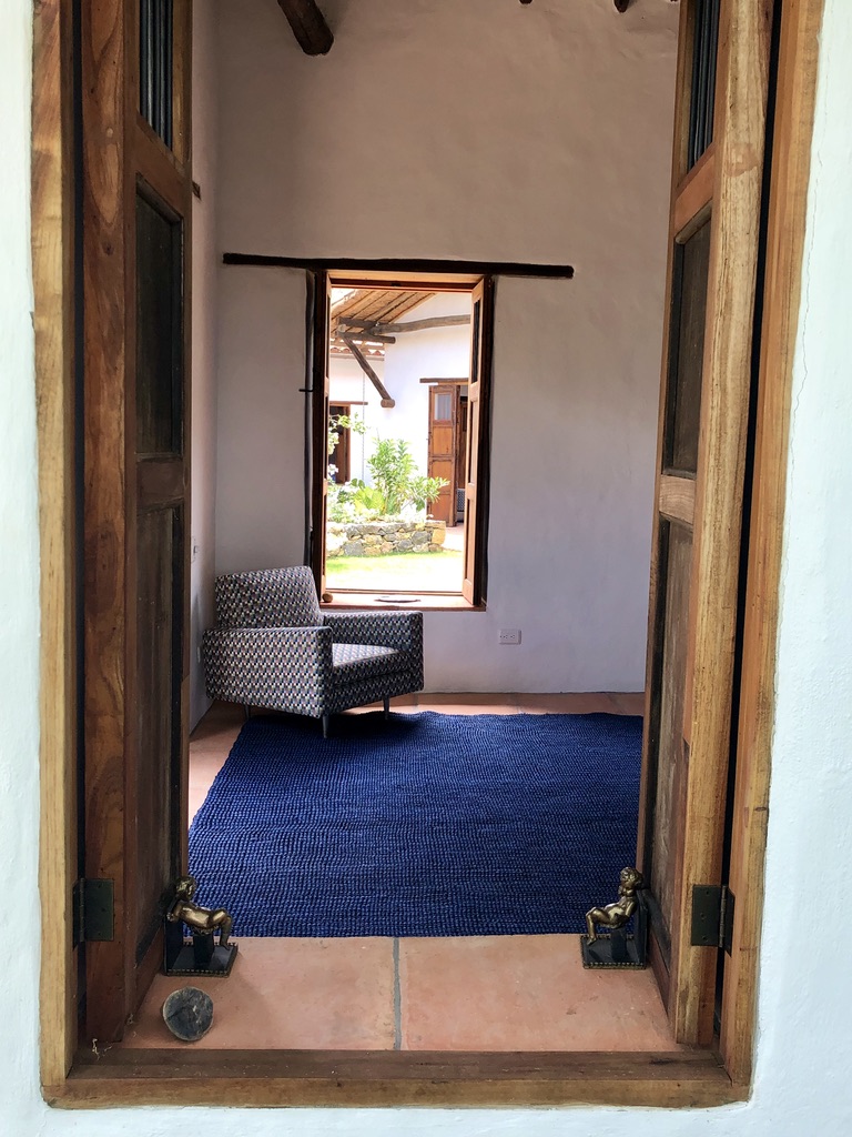 View through timber doors into the bedroom with its window onto the courtyard garden