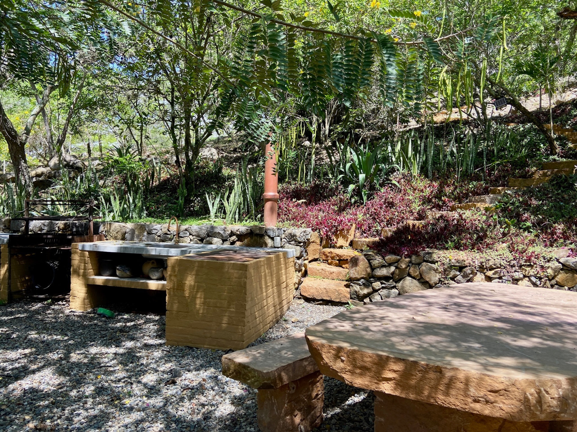 Outdoor kitchen with stone counter, grill and carved stone table