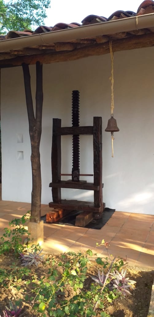 Tobacco press and iron bell beneath the tiled veranda