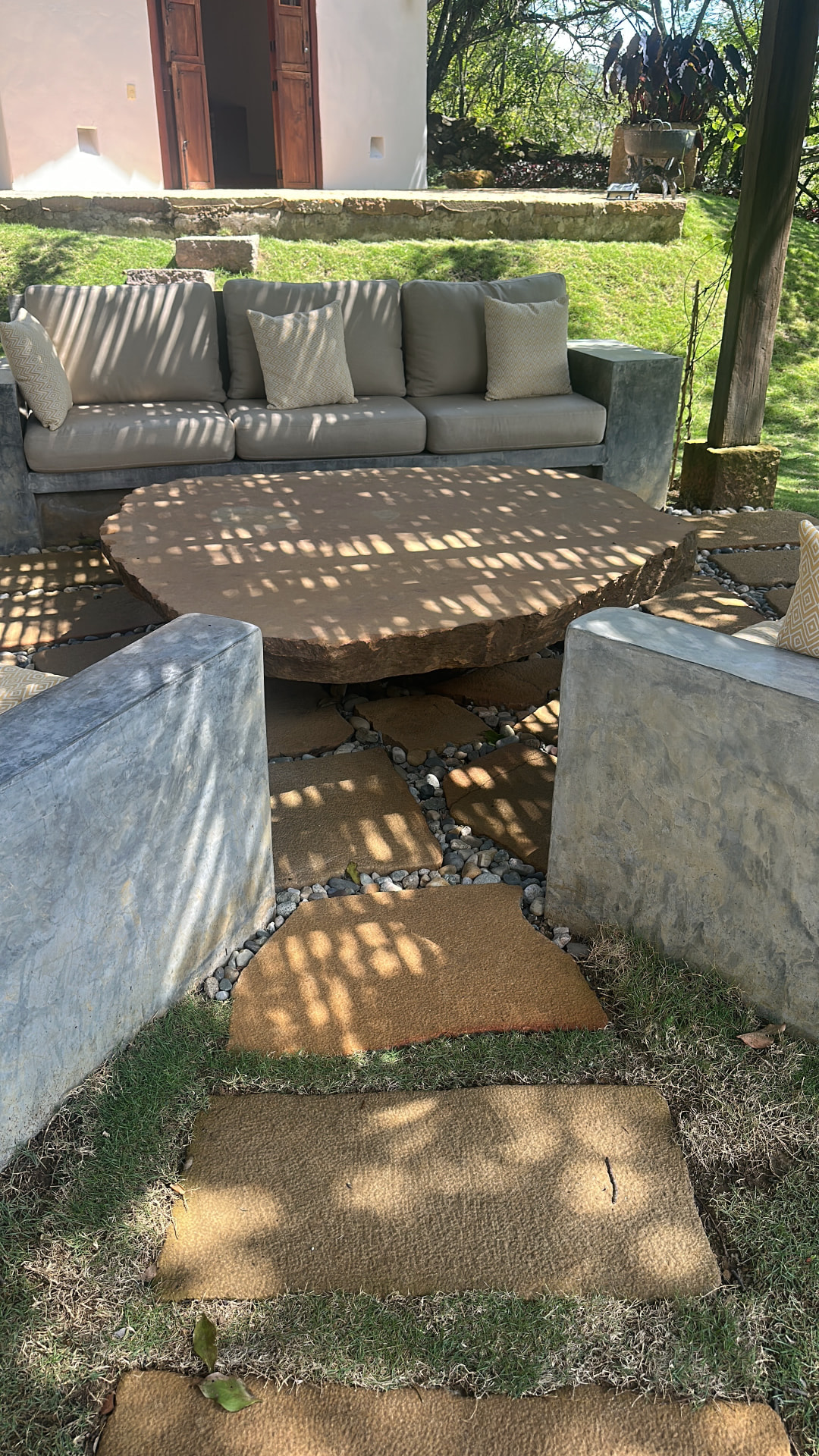Garden lounge with concrete sofas around a round stone table