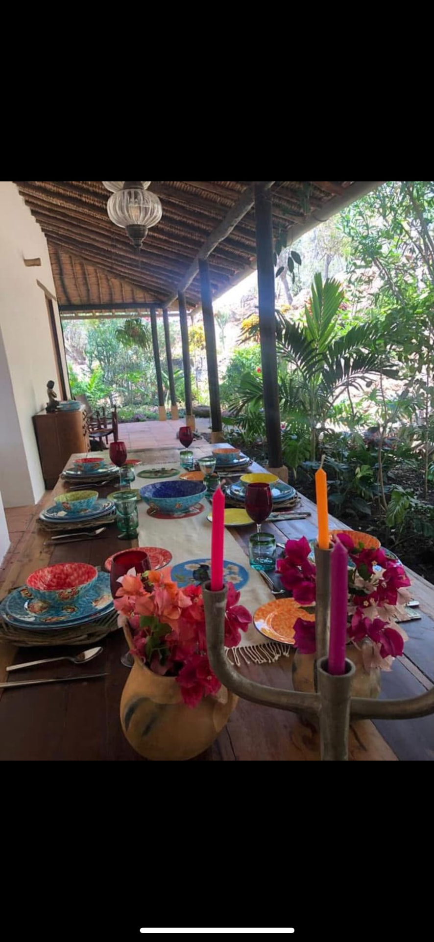 Table laid with candles and bougainvillea beside the garden