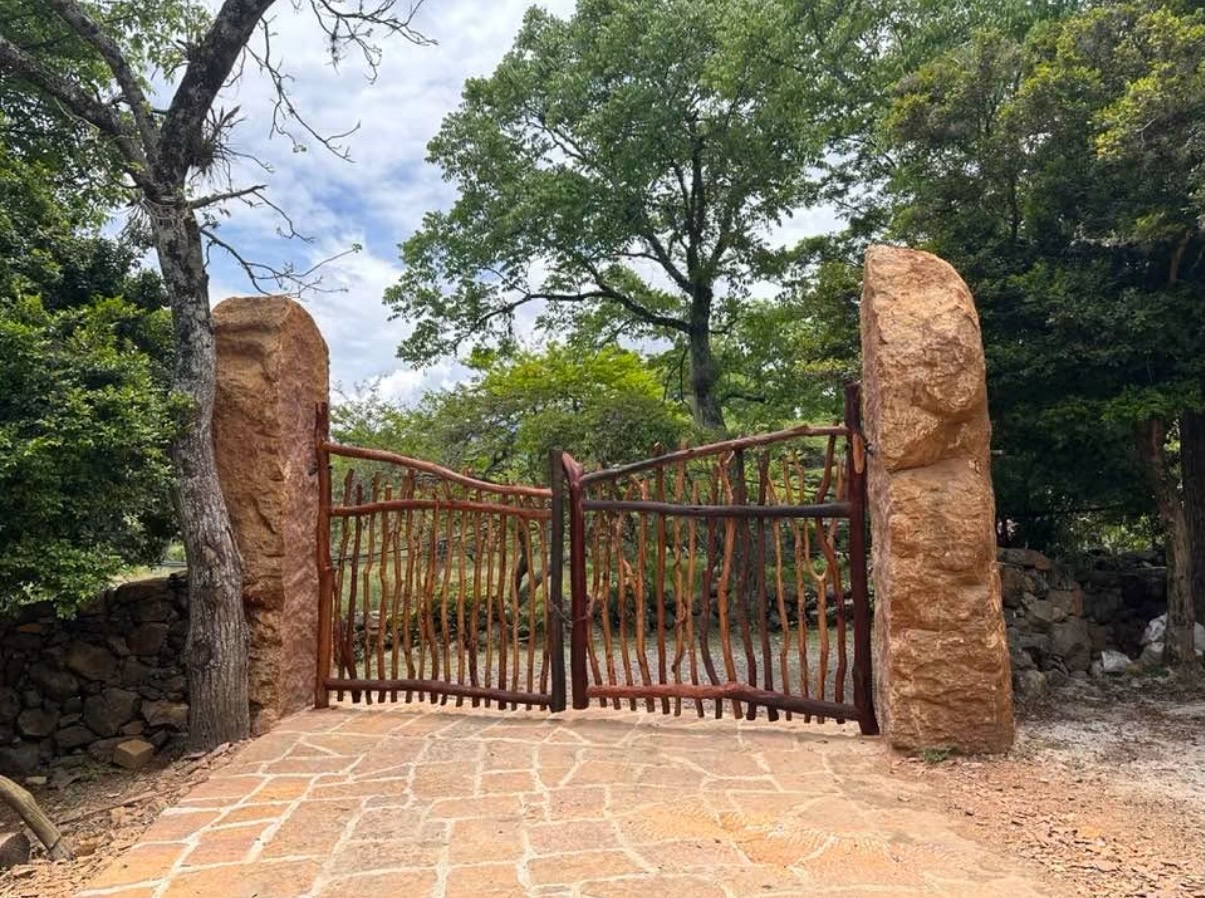 Hand-carved wooden gate set into a native stone wall