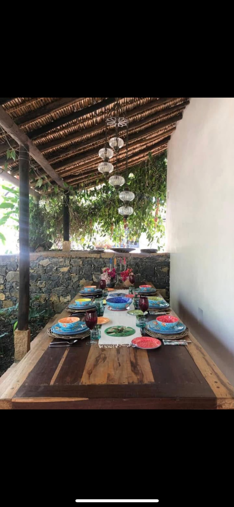Dining table under the cane roof with glass lanterns overhead