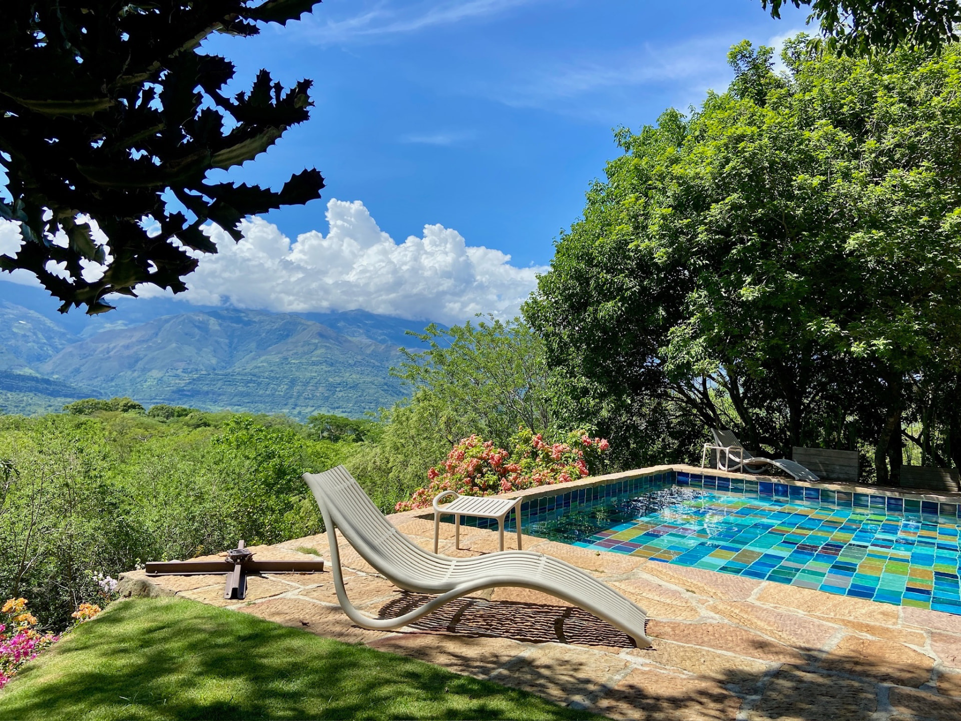 Mosaic-tiled pool and lounger looking out to the Uchata mountains