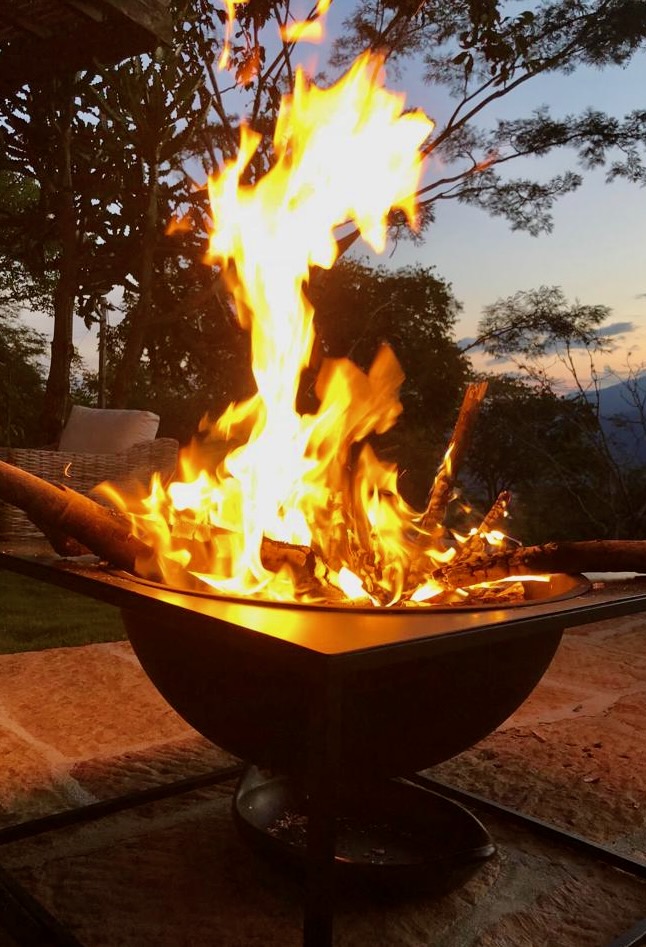 Fire pit burning at dusk with the mountains behind